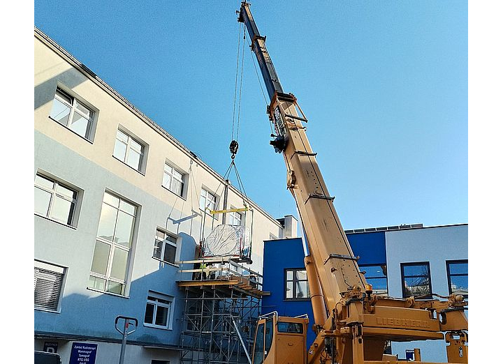 Dzwig podnosi części tomografu